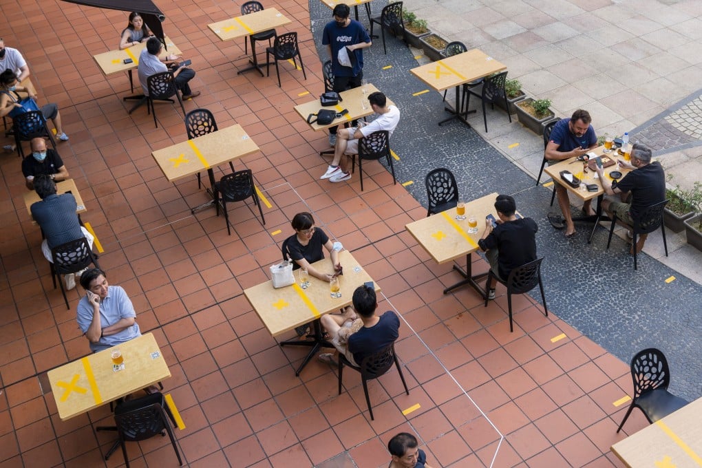 Customers sit at socially distanced tables outside a restaurant in Singapore. Photo: Bloomberg