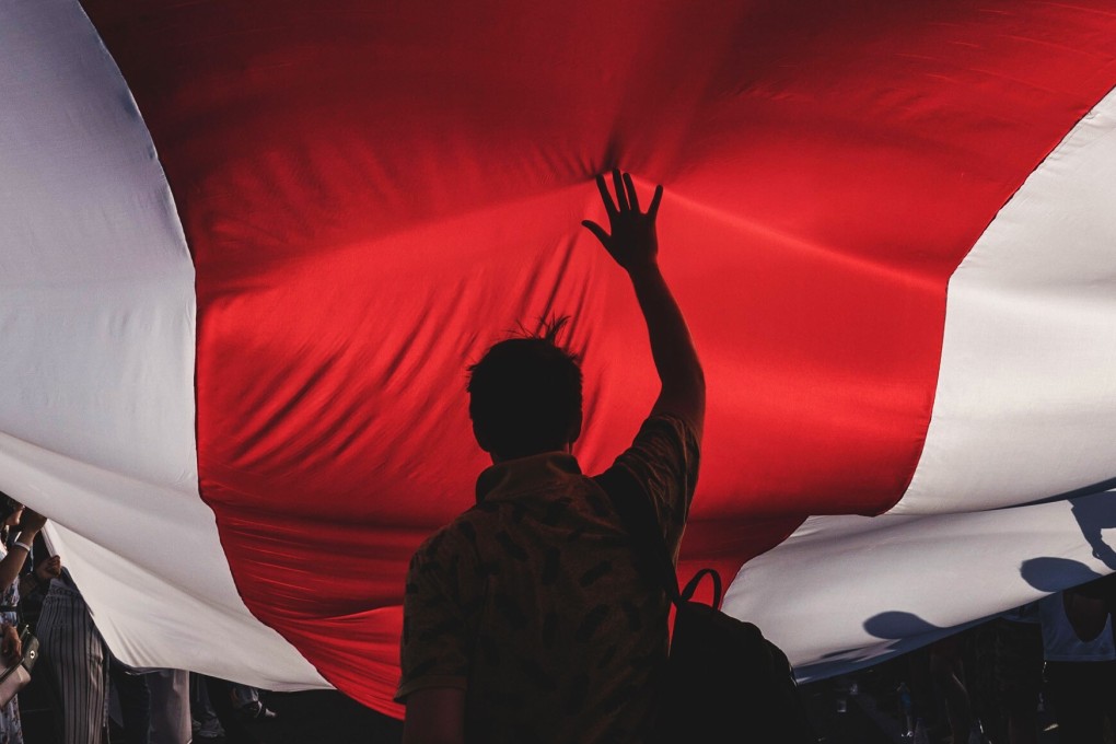 Protesters unfurl a banner in the colours of the former Belarus national flag in Minsk in 2020. File photo: Bloomberg