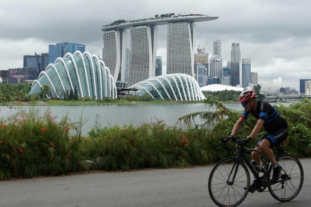 A cyclist rides along Marina Bay overlooking Singapore’s financial business district. Photo: AFP