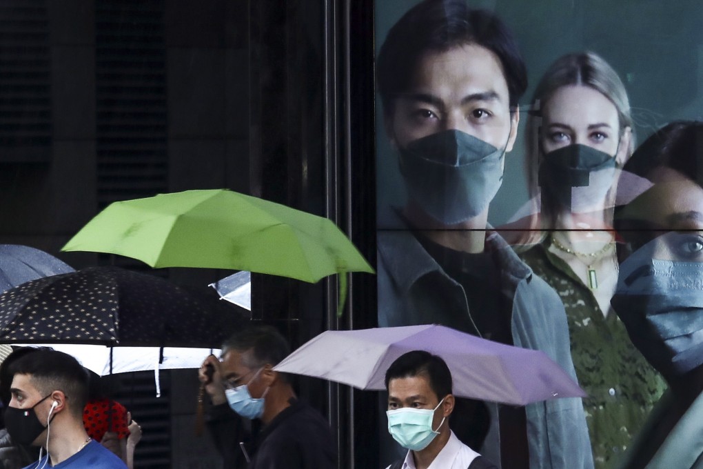 Hongkongers walk past an advert for medical masks in Central on Tuesday. Photo: Jonathan Wong