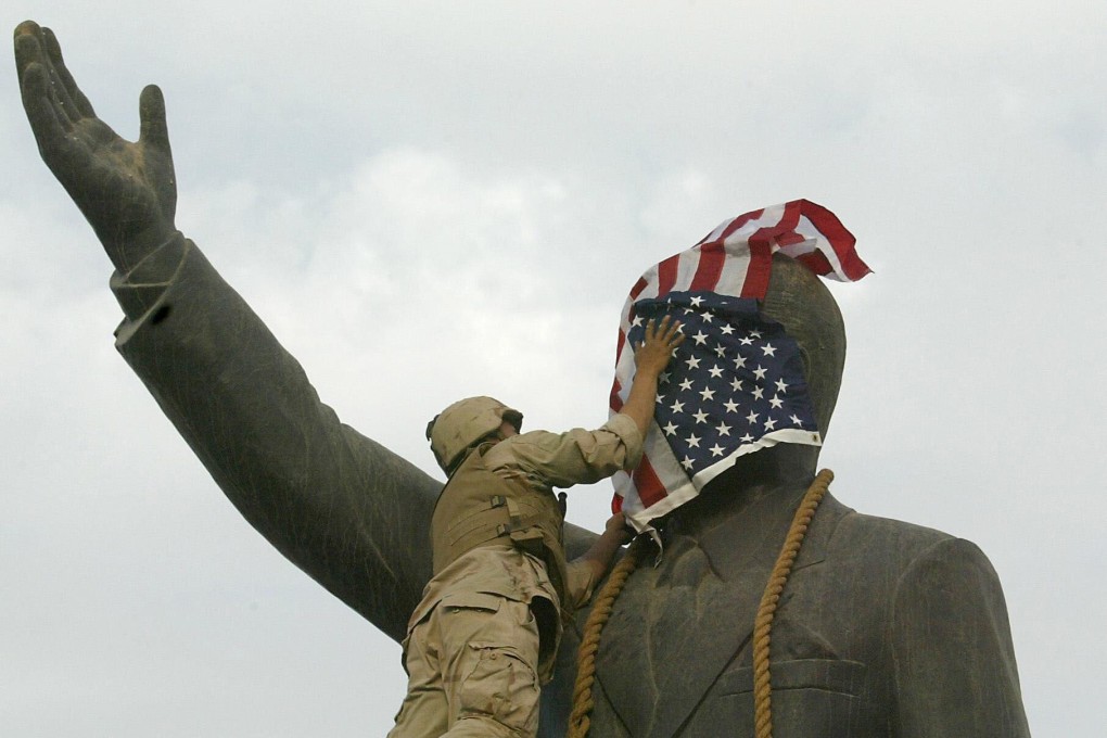 A US Marine covers the face of Saddam Hussein's statue with the US flag in Baghdad in 2003. File photo: AFP