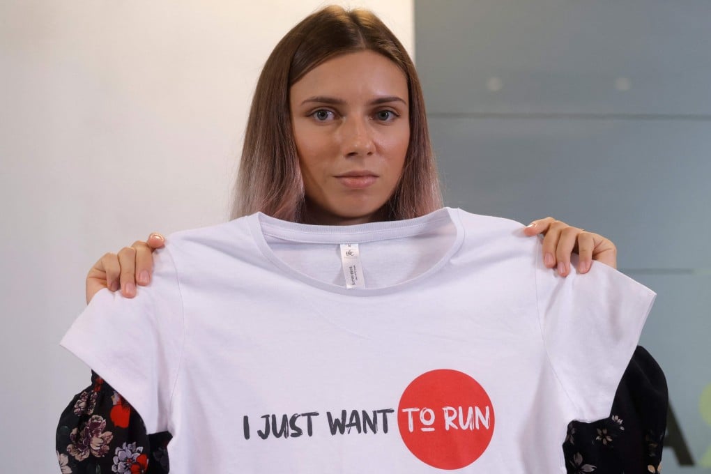 Belarusian Olympic athlete Krystsina Tsimanouskaya poses with T-shirt with the lettering reading 'I just want to run' in Warsaw, after her arrival in Poland. Photo: AFP