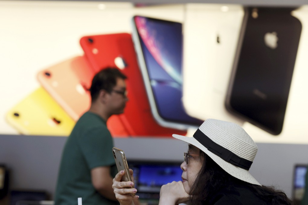 In this May 10, 2019, file photo, a customer looks at her iPhone at an Apple store in Beijing. Apple suppliers in China are currently scrambling to hire new workers for the ramp-up of the iPhone 13. Photo: AP