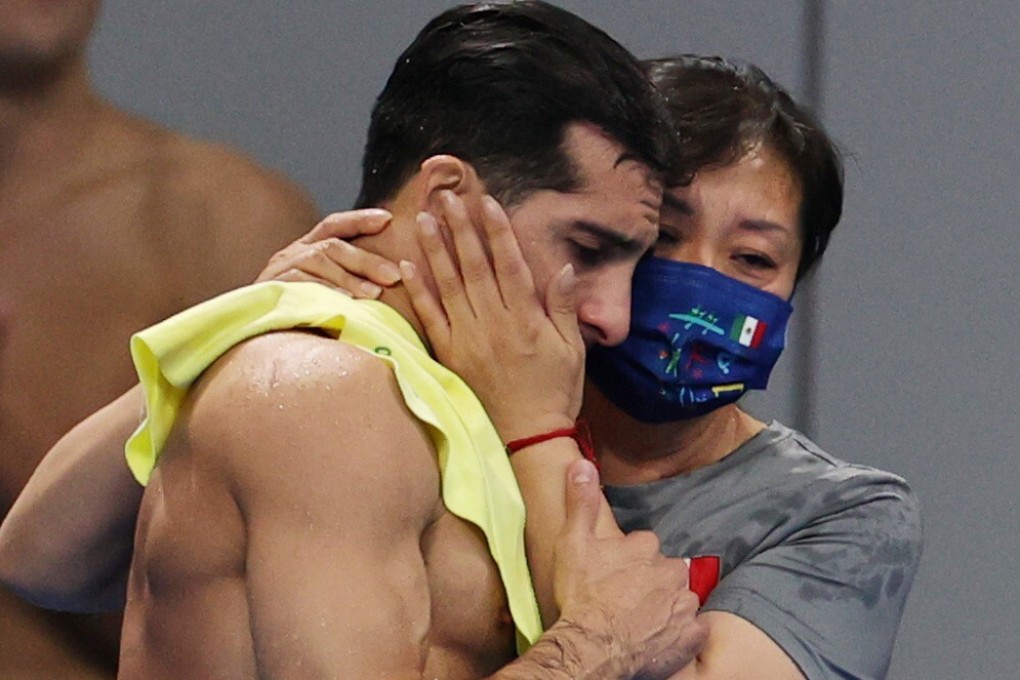 Rommel Pacheco, one of the most popular athletes in Mexico, is hugged by his coach Ma Jin. Photo: Reuters
