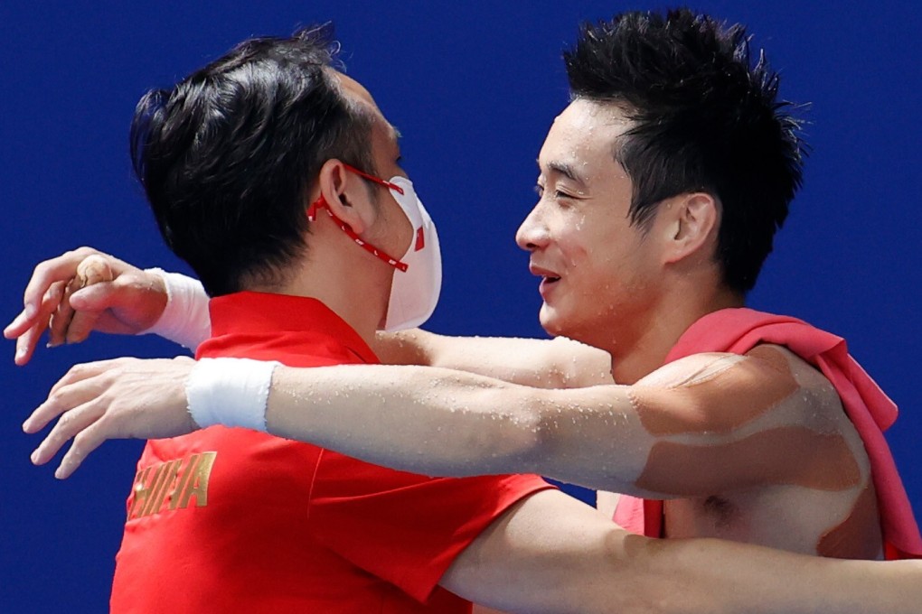 China’s Cao Yuan celebrates with his coach after winning gold in the men’s 10m platform final at the Tokyo 2020 Olympic Games. Photo: DPA