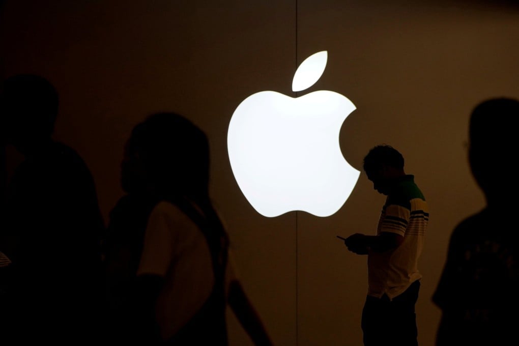 A man looks at the screen of his mobile phone in front of an Apple logo outside its store in Shanghai on July 30, 2017. Photo: Reuters