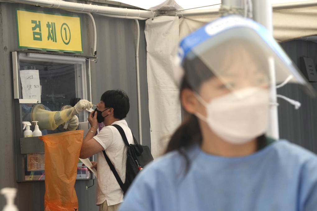A medical worker takes a nasal swab from a man for Covid-19 testing at a makeshift testing site in Seoul. Photo: AP