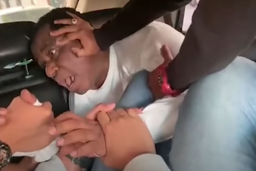 A video showing three Indonesian officials pinning a Nigerian diplomat into the back seat of a moving car has gone viral online. Photo: YouTube