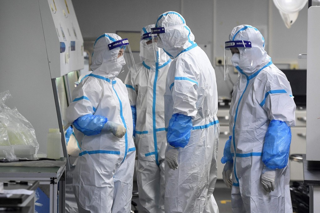 Laboratory technicians wearing personal protective equipment handle samples to be tested for Covid-19 in Wuhan, China, following an outbreak of the Delta variant in the city. Photo: AFP