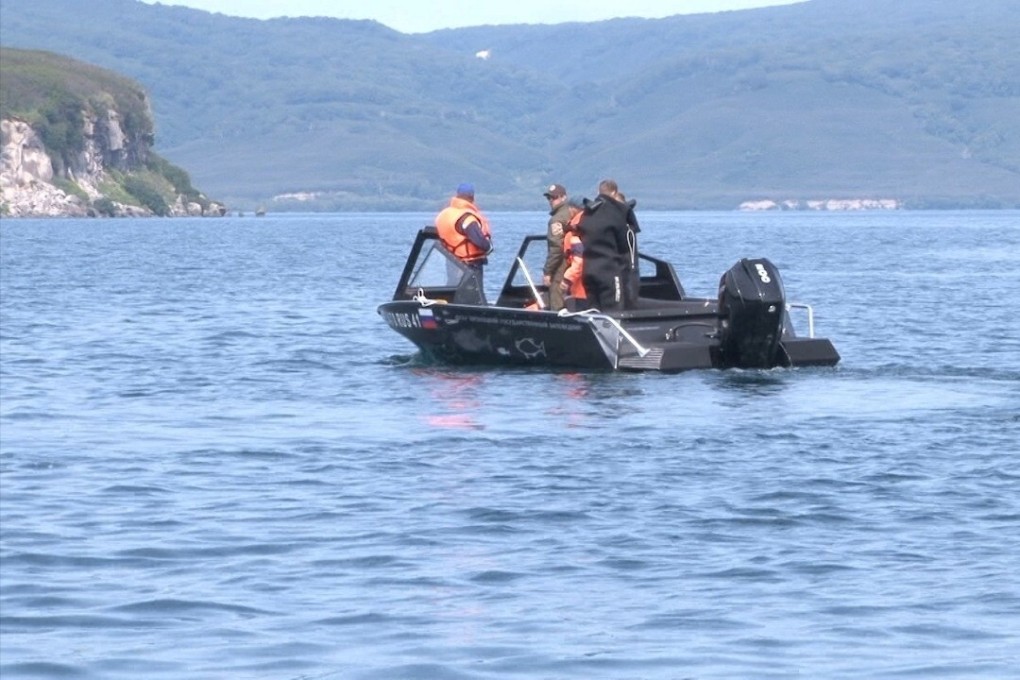 Emergency workers conduct a search and rescue operation after a helicopter carrying 16 people, most of them tourists, crashed in Kurilskoe Lake in Russia. Photo: Reuters