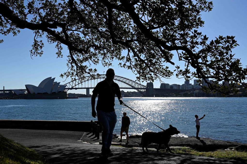 Residents walk along the Sydney Harbour on Friday. Photo: AFP