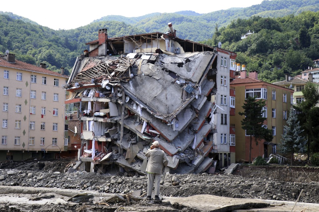 A man looks at a destroyed building in Bozkurt, Kastamonu province, Turkey on Saturday after severe floods and mudslides killed at least 55. Photo: AP