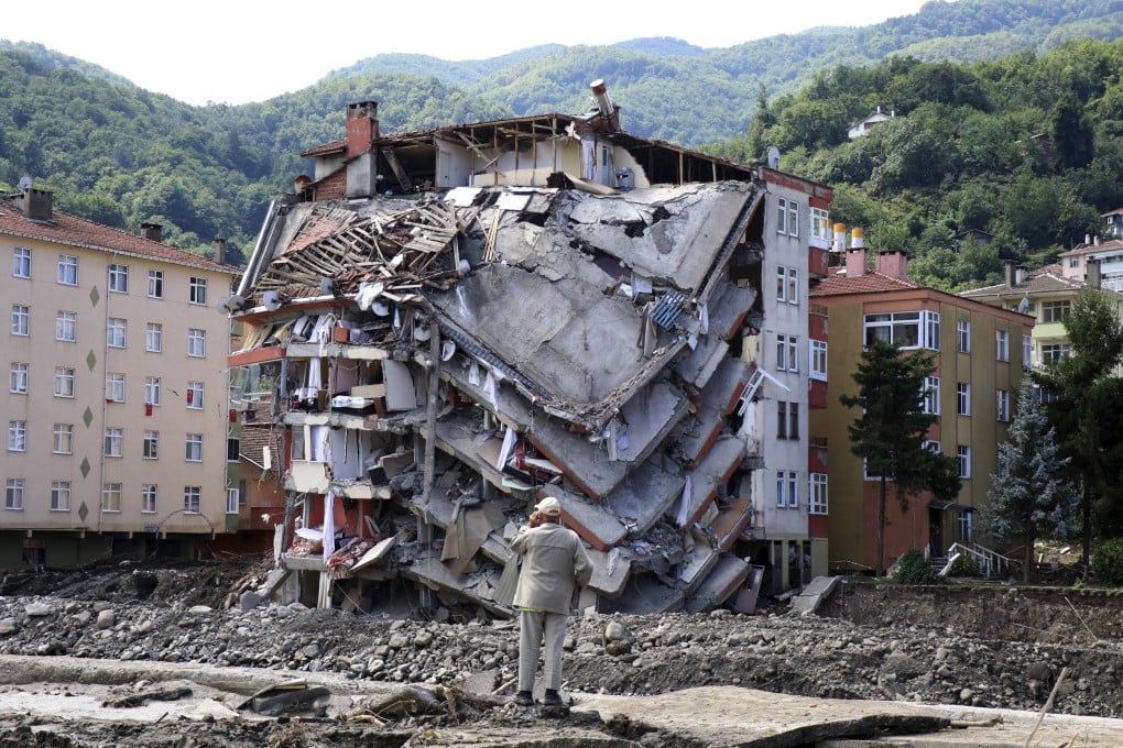 A man looks at a destroyed building in Bozkurt, Kastamonu province, Turkey on Saturday after severe floods and mudslides killed at least 55. Photo: AP