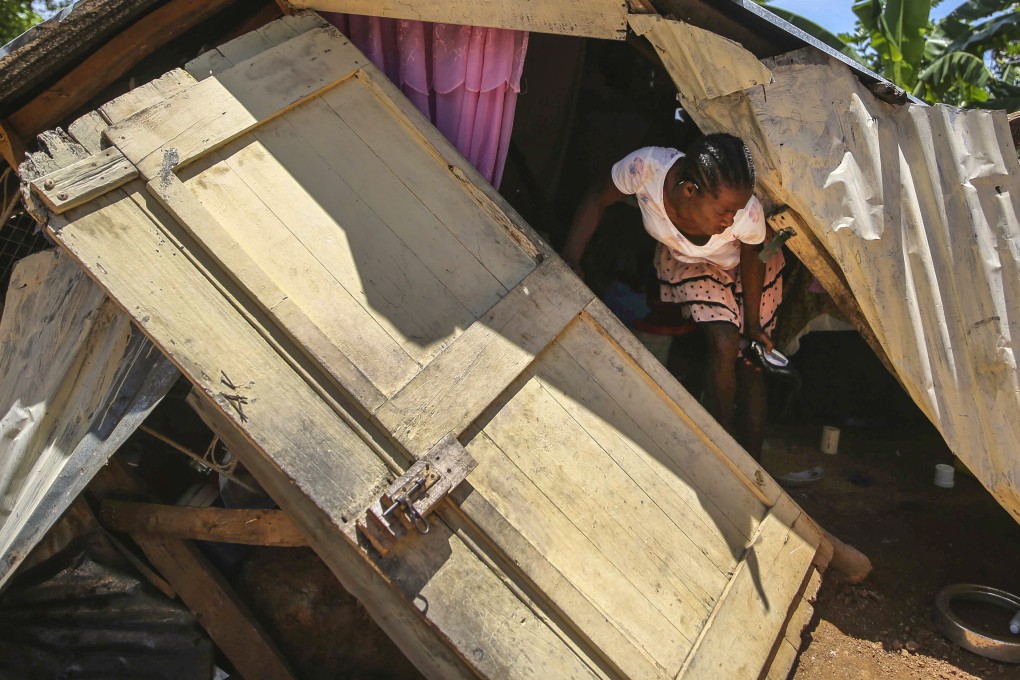 A woman walks in the rubble of her earthquake destroyed home as she attempts to recover her belongings, in Les Cayes, Haiti. Photo: AP