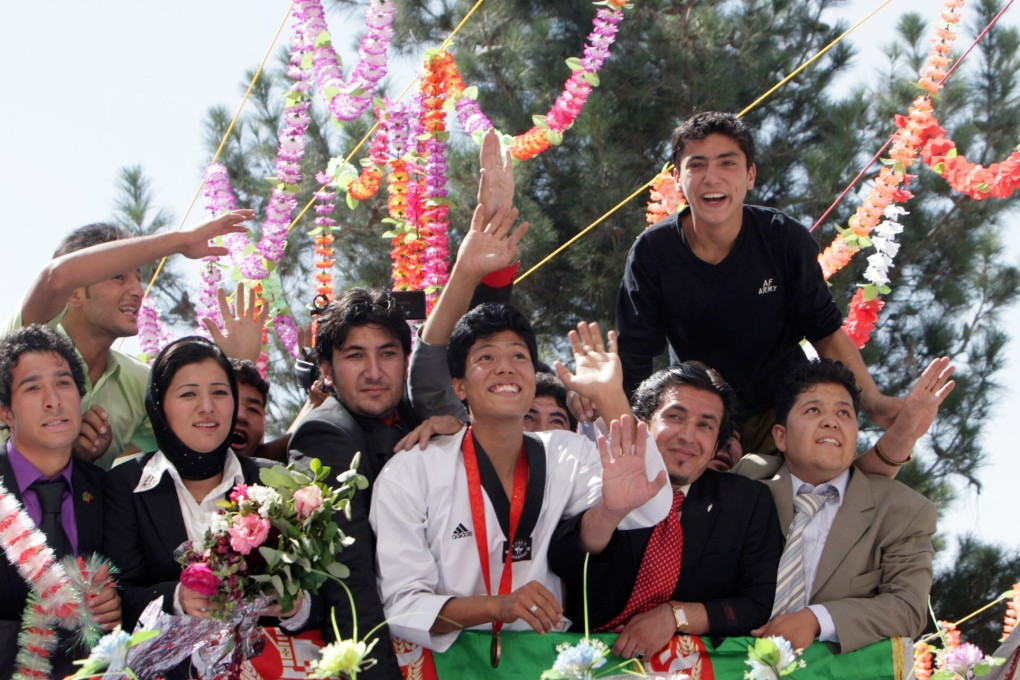 Afghan Olympic athlete Rohullah Nikpai, centre, with a medal around his neck, arrives in Afghanistan following the 2008 Beijing Olympics. Photo: AP