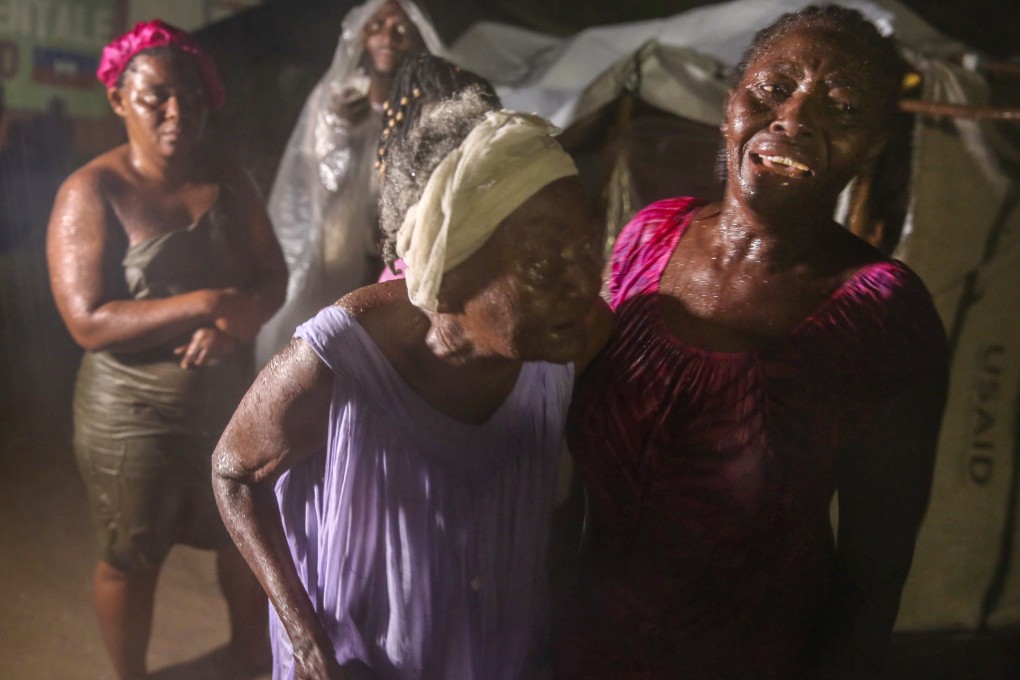 People affected by Saturday's earthquake stand in the rain at a refugee camp in Les Cayes, Haiti. Photo: AP