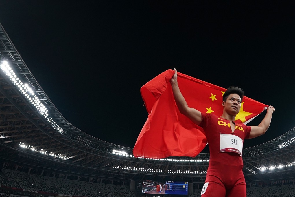 Su celebrates with the Chinese national flag after the men‘s 100m final at the Tokyo 2020 Olympic Games. Photo: Xinhua