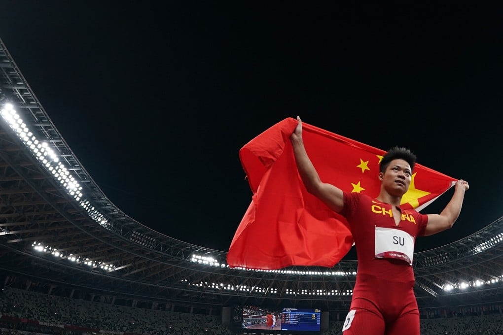 Su celebrates with the Chinese national flag after the men‘s 100m final at the Tokyo 2020 Olympic Games. Photo: Xinhua