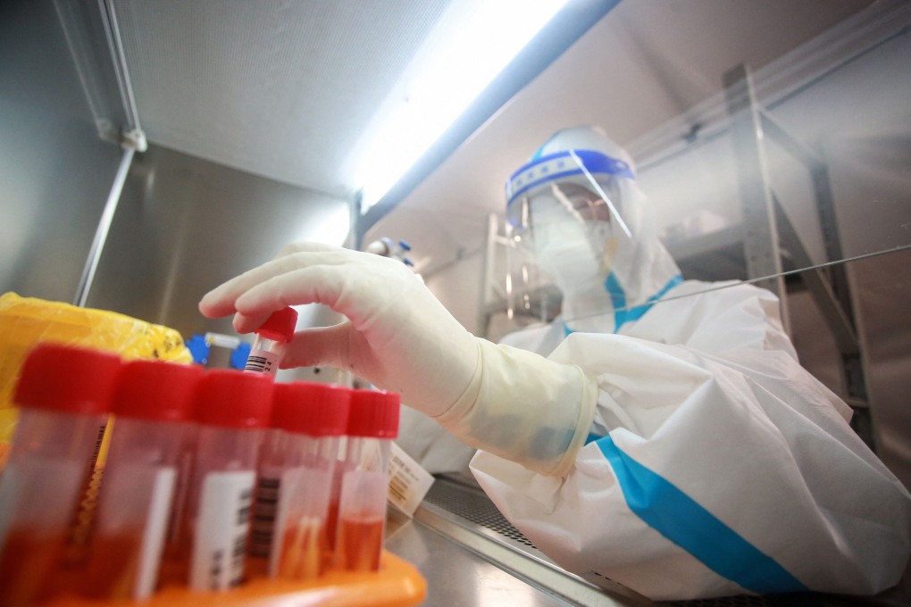A laboratory technician works on samples to be tested for Covid-19 at a facility in Yangzhou, Jiangsu province on Friday. Photo: STR/AFP