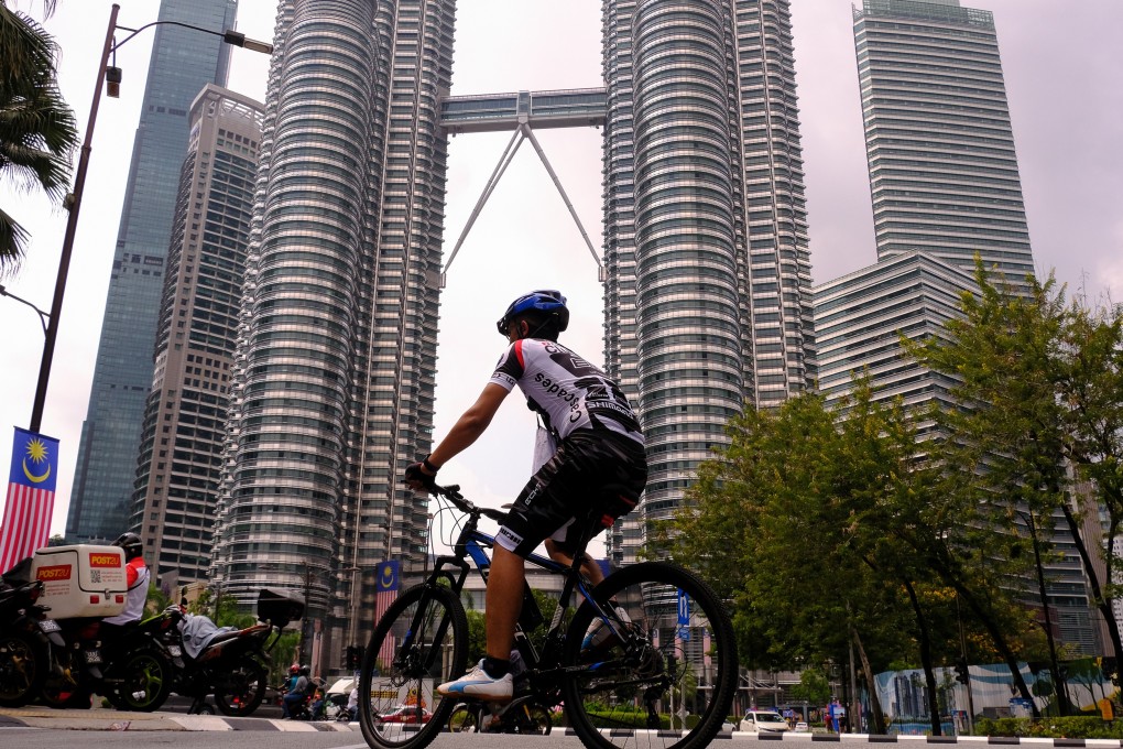 A cyclist rides along a deserted street near the Petronas Twin Towers in Kuala Lumpur, Malaysia, on Wednesday. Photo: Bloomberg