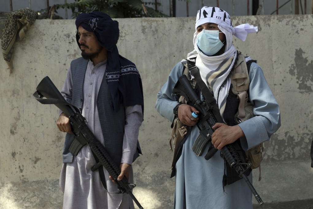 Taliban fighters stand guard at the main gate leading to the Afghan presidential palace in Kabul, Afghanistan, on Monday. Photo: AP