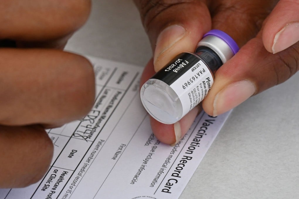 A health worker fills out a Covid-19 vaccination card in Los Angeles on August 11. Photo: AFP