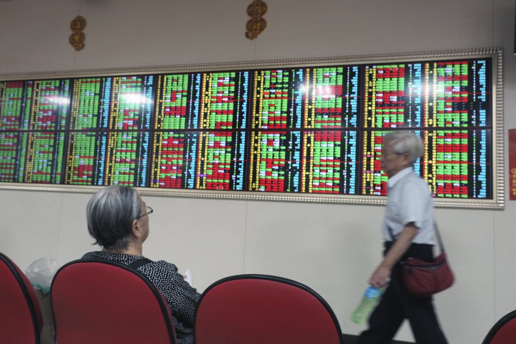 Investors watch stock prices inside a brokerage hall. Stocks in Hong Kong rebound as market awaits Tencent’s earnings report. Photo: EPA