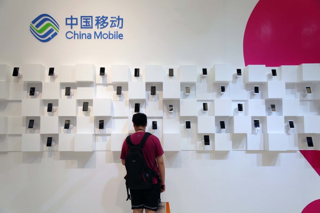 A visitor is seen at the stand of China Mobile during an exhibition in Shanghai on July 16, 2015. Photo: Handout