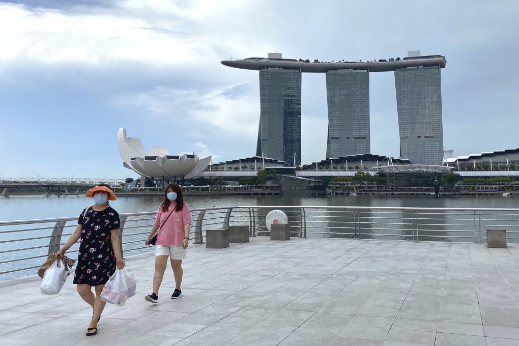 Visitors wear masks while walking around Singapore’s Merlion Park. Photo: AP
