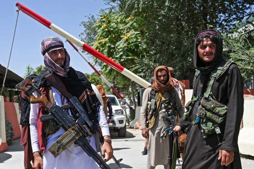 Taliban fighters stand guard along a road near Zanbaq Square in Kabul on Monday. Photo: TNS