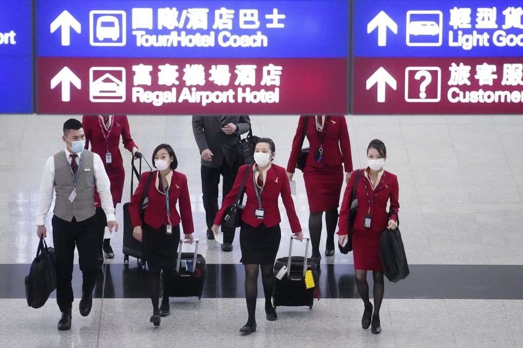 Cathay Pacific staff walk through the arrivals hall at Hong Kong International Airport. Photo: Winson Wong