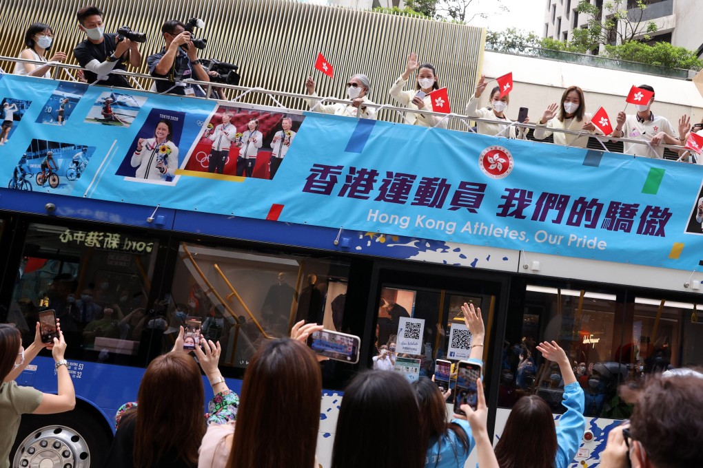 Hong Kong residents snap photos as the city’s Olympic team rolls along Thursday’s parade route. Photo: Nora Tam