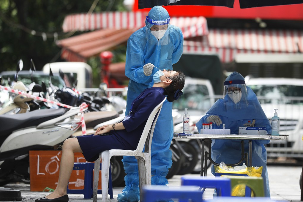 A health worker collects swab samples from a woman for Covid-19 testing in Hanoi, Vietnam. Photo: EPA-EFE