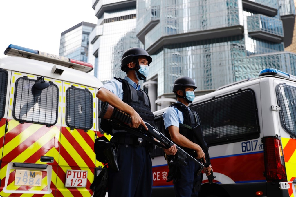 Police officers stand guard as activist Andy Li is brought to the High Court on Thursday. Photo: Reuters