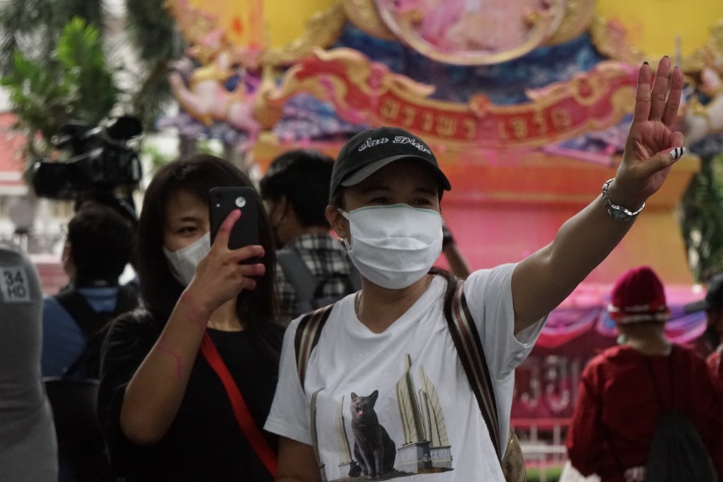 A young Thai protester in Bangkok gives the three-fingered salute adapted from the Hollywood movie The Hunger Games.
