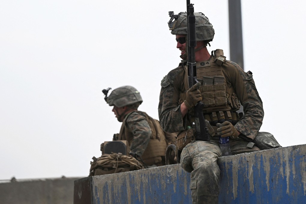 US soldiers stand guard as Afghans gather near the military part of the airport in Kabul hoping to flee. Photo: AFP