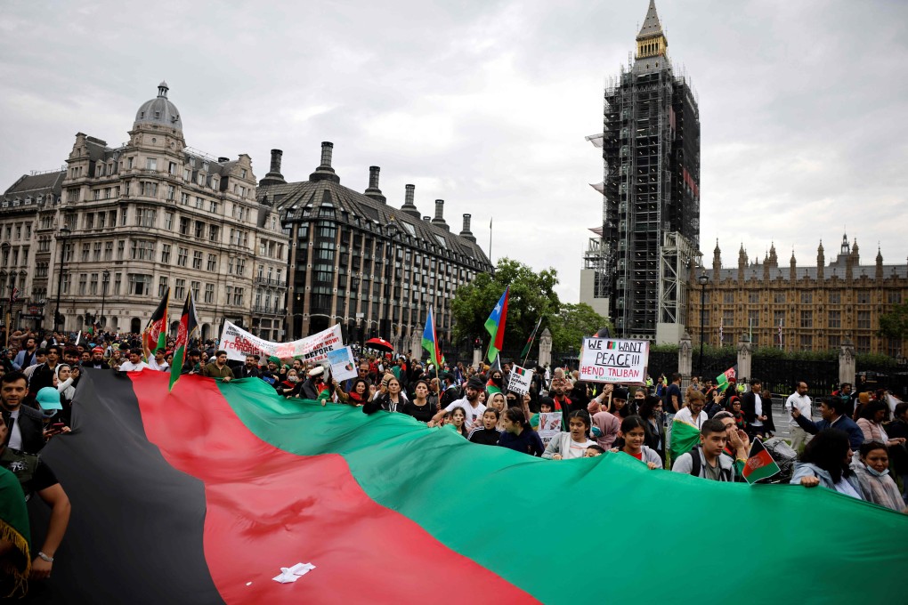 Protesters display a giant Afghan flag as they demonstrate in solidarity with the people of Afghanistan in Parliament Square, London on Saturday. Photo: AFP