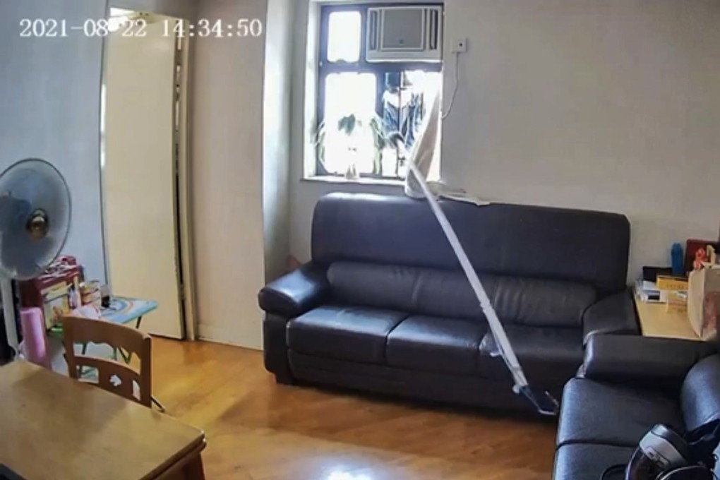 A Hong Kong burglar climbed 10 storeys of scaffolding on Sunday, then used a pole to reach through a window and snare a purse. Photo: Screengrab