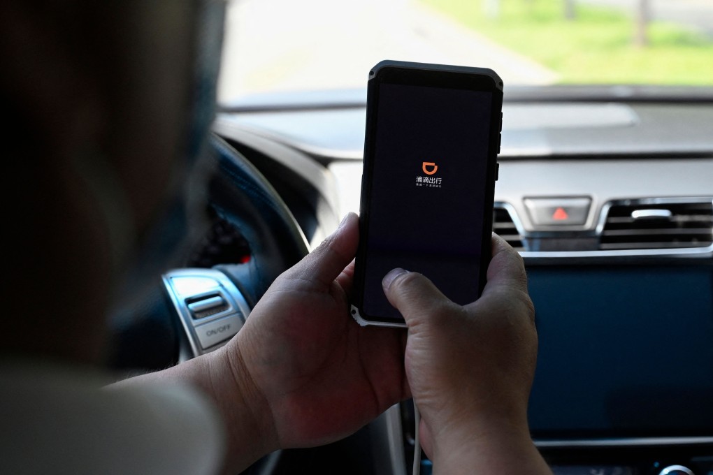 A driver opening the Didi Chuxing ride-hailing app on his smartphone in Beijing, 2021. Photo: AFP