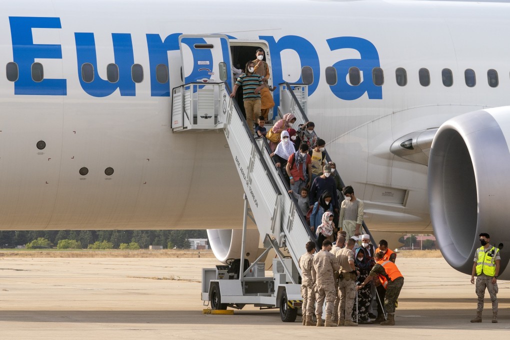 Afghan people who were transported from Afghanistan, disembark a plane, at the Torrejon military base as part of the evacuation process in Madrid, Spain. Photo: AP