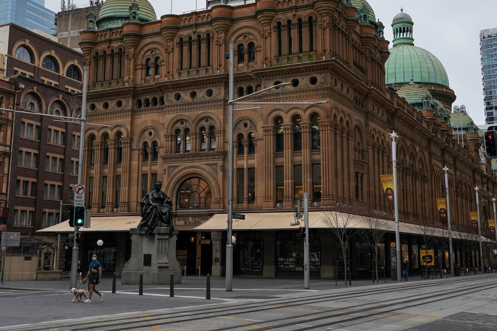 A man walks a dog through the quiet city centre during a lockdown in Sydney, Australia. Photo: Reuters