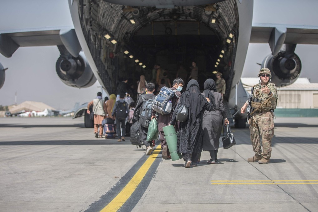 Evacuees board a US Air Force C-17 aircraft at Hamid Karzai International Airport in Kabul on Monday. Photo: US Air Marine Corp via AFP