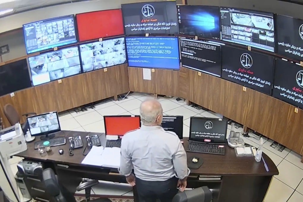 A guard looks at surveillance screens taken over by the hacker group at Evin prison in Tehran, Iran. Photo: The Justice of Ali via AP