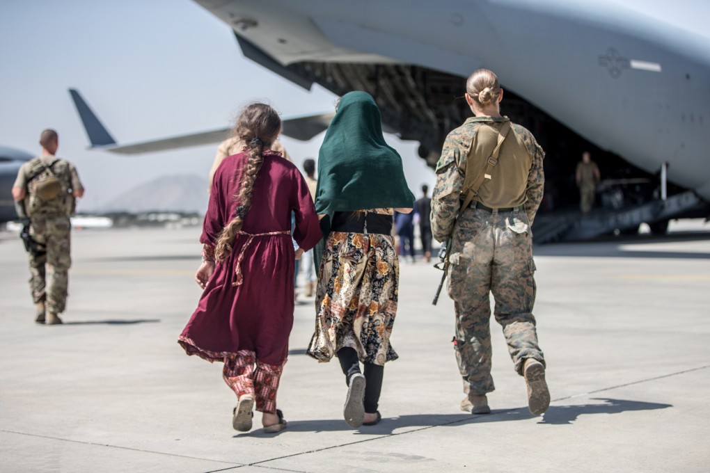 A US marine walks youngsters to an evacuation flight on Tuesday at Hamid Karzai International Airport in Kabul, Afghanistan. Photo: Sgt. Samuel Ruiz/US Marine Corps/Handout via Reuters