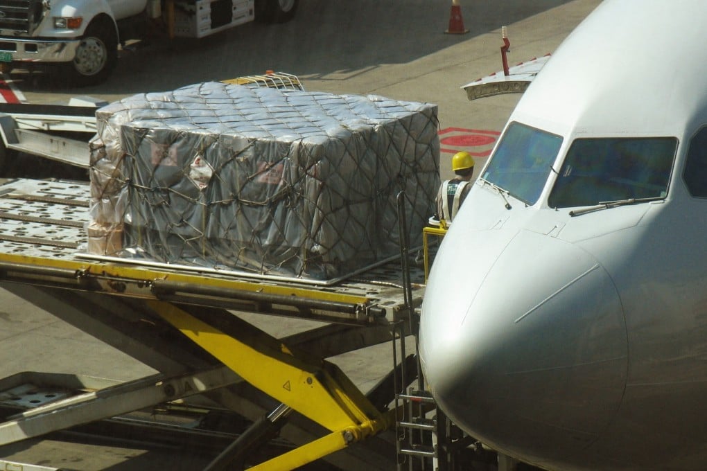 Workers unload goods onto a plane at Shanghai Pudong International Airport, where recent cases of coronavirus among workers have caused freight delays and diverted flights. Photo: AFP