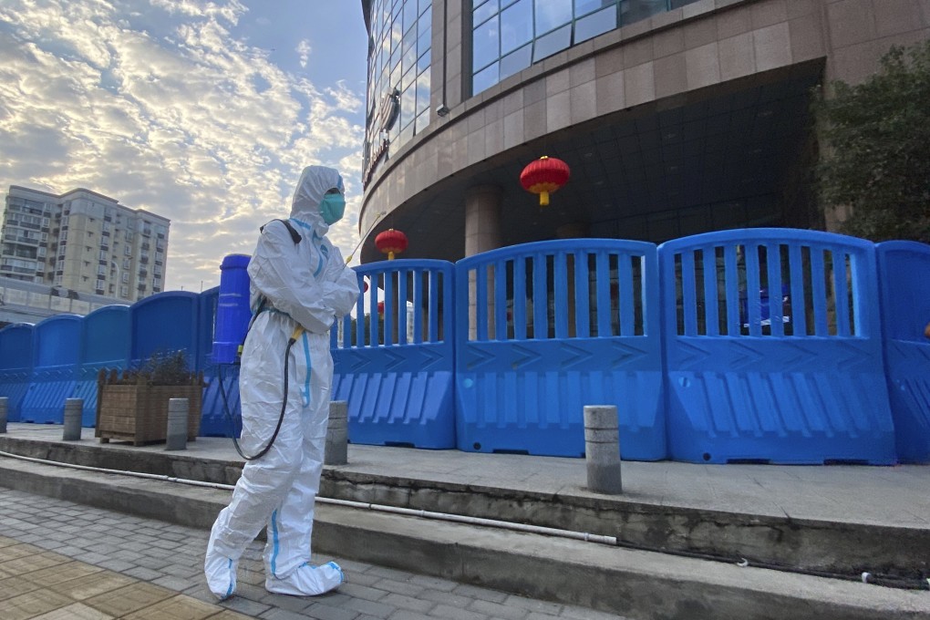 A worker carrying disinfecting equipment walks outside Wuhan Central Hospital in China in February. Photo: AP