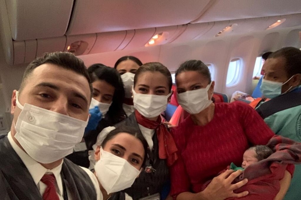 Turkish Airlines cabin crew members pose with the newborn baby girl on board an evacuation flight from Dubai to Birmingham. Photo: Turkish Airlines via Reuters