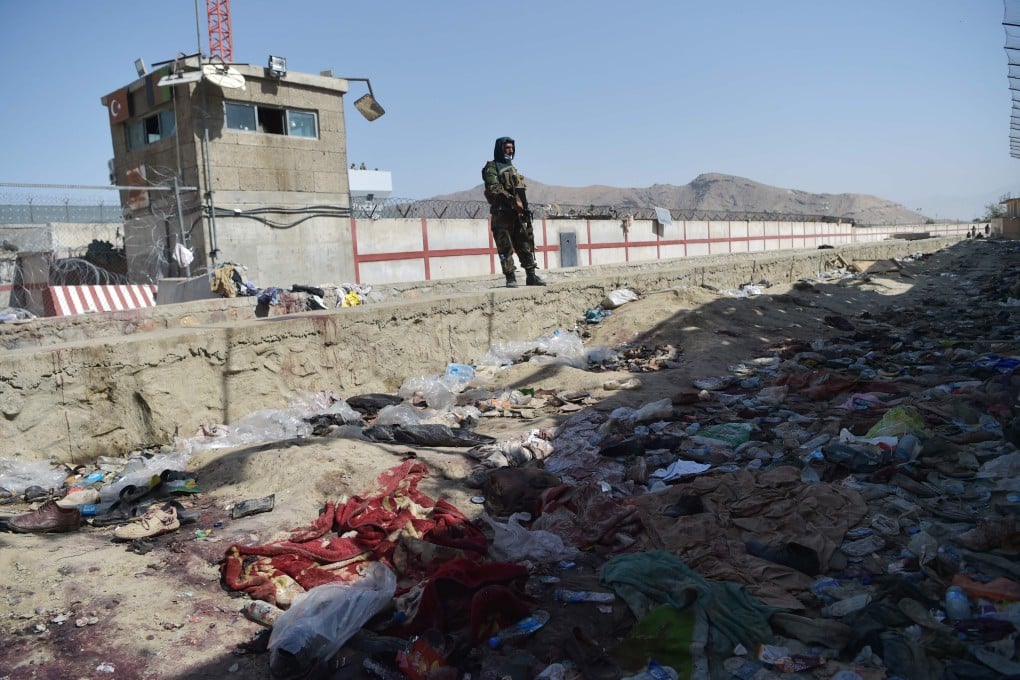 A Taliban fighter stands guard at the site of the August 26 twin suicide bombs at Kabul airport on Friday. Photo: AFP