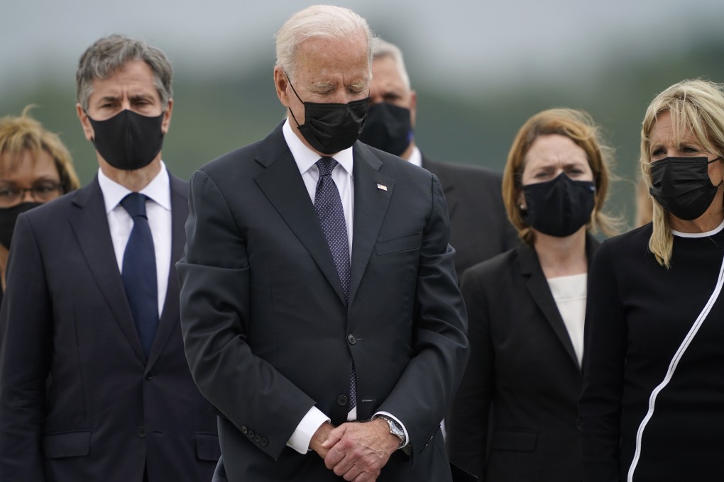 US President Joe Biden bows his head as first lady Jill Biden, right, and Secretary of State Antony Blinken, left, watch during a casualty return at Dover Air Force Base in Delaware on Sunday. Photo: AP