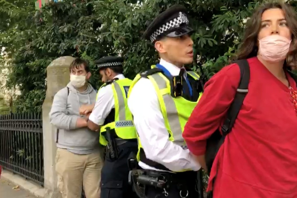 Police officers detain Extinction Rebellion climate demonstrators near the Science Museum in London on Monday. Photo: Extinction Rebellion UK via Reuters